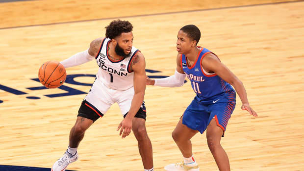 Mar 11, 2021; New York, NY, USA; Connecticut Huskies forward Akok Akok (11) dribbles against DePaul Blue Demons guard Charlie Moore (11) during the first half at Madison Square Garden. Mandatory Credit: Vincent Carchietta-USA TODAY Sports